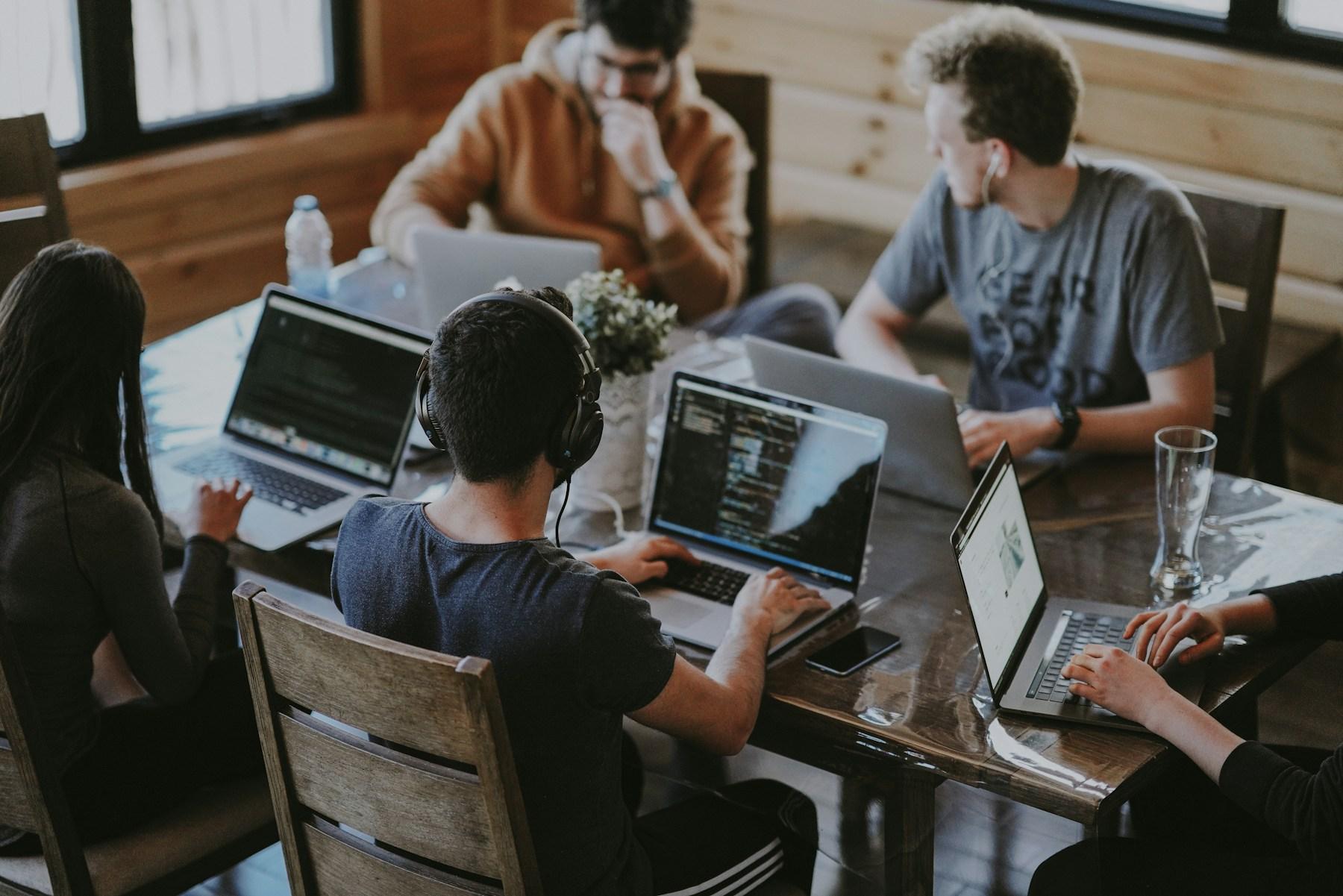 Team collaborating around computers in a shared workspace